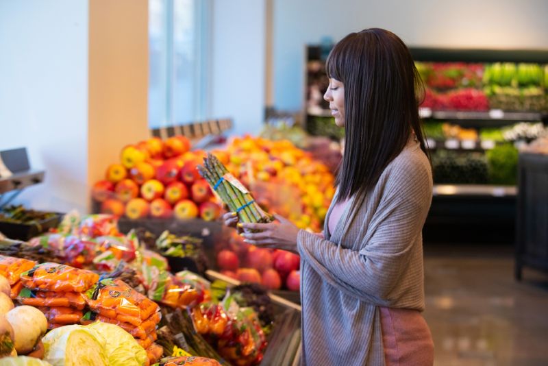 woman shopping for vegetables in grocery store
