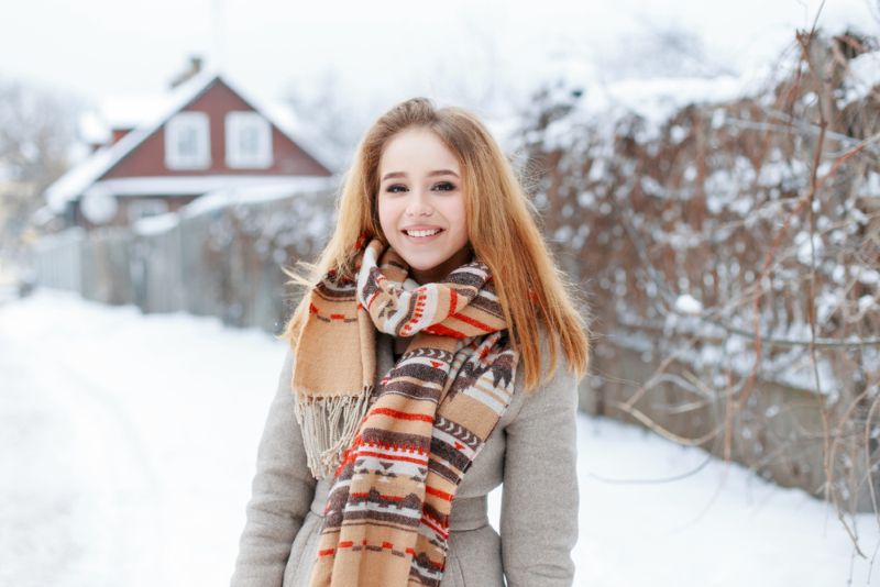 woman bundled in warm clothes standing outside in the snow