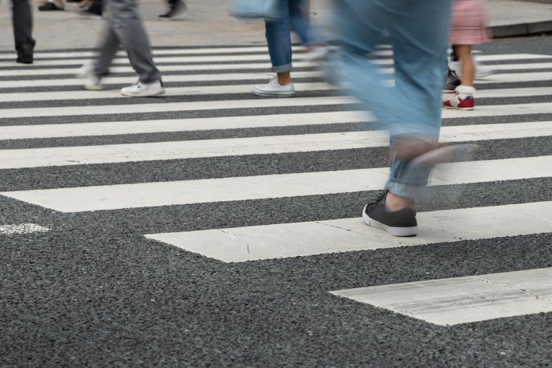 blurred image of legs quickly crossing the street