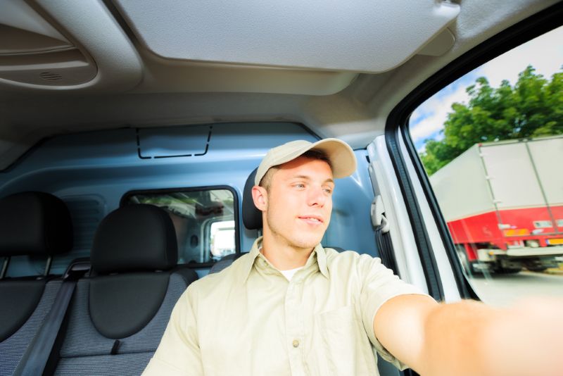Delivery truck driver smiling while working