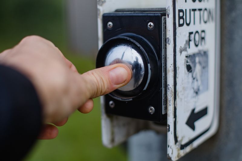 Pushing the crosswalk button to cross the street