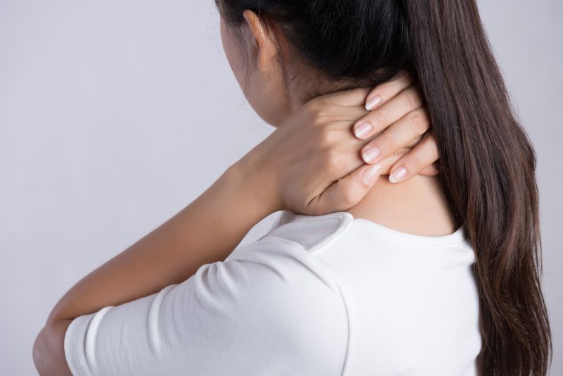 Woman holding the back of her neck in pain