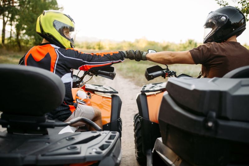 Friends bumping fists on their ATVs